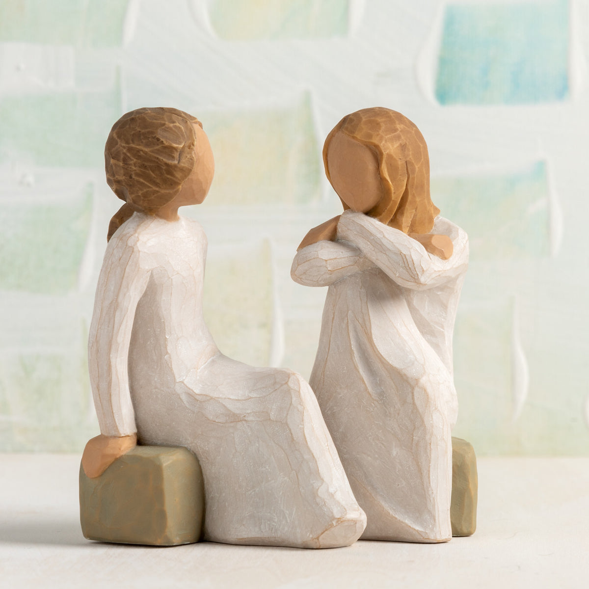 Willow Tree Heart and Soul, 4"h hand-painted resin figure of two women in cream dresses, seated on gray bench, facing each other, in front of pale green painting