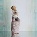Willow Tree something special, 5.5”h hand-painted figure of small boy holding plant in pot, kneeling on tall rock etched with nature imagery, in front of grey painting