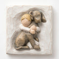 Close up of carved white square stone - in the middle is faceless young boy holding larger brown dog