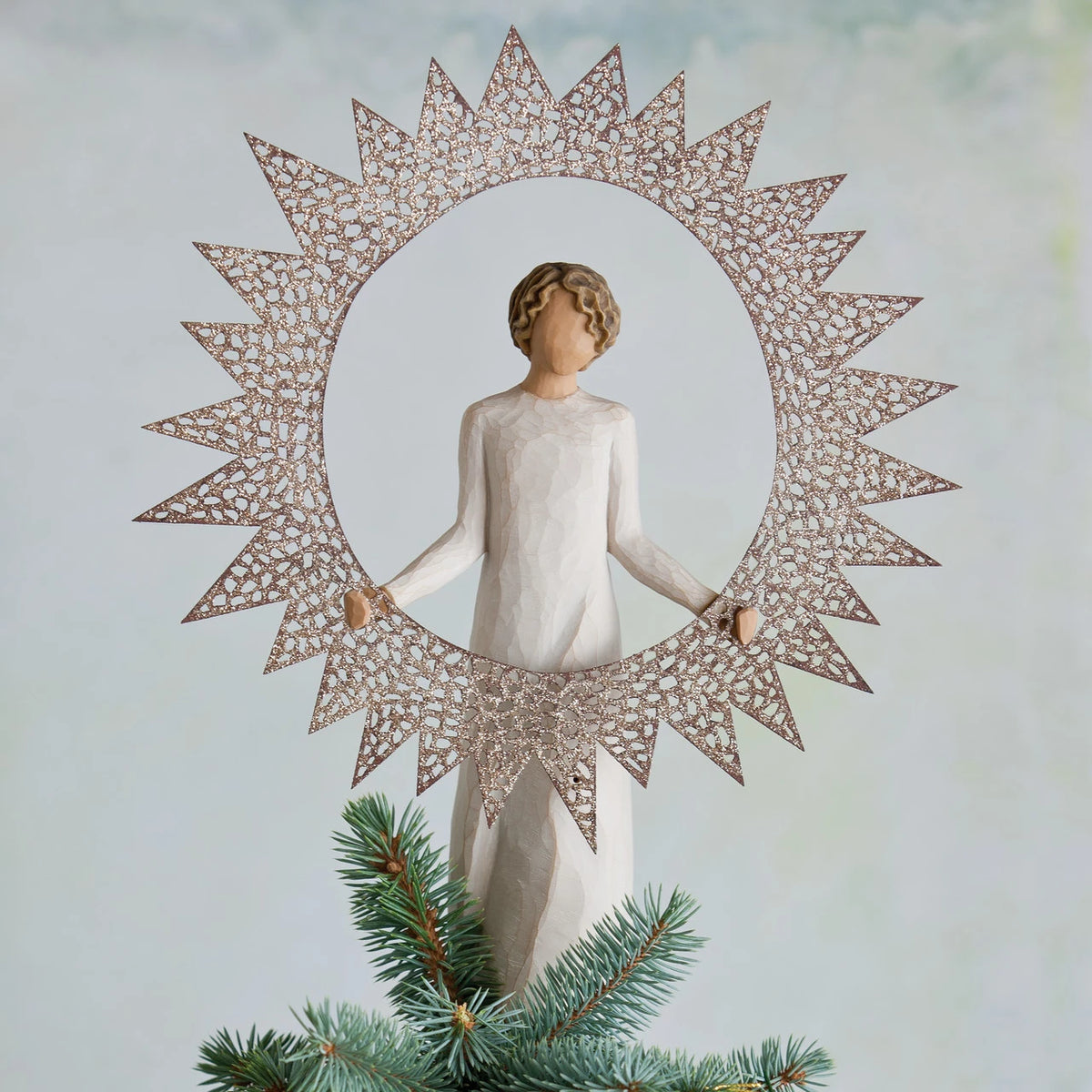 Faceless woman figurine wearing white standing holding round sun figurine around her body