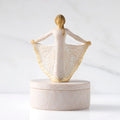 Front view: oval resin box, with 3-D figure in cream and gold carved dress atop lid