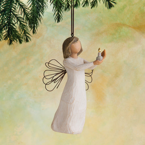 Willow Tree Angel of Hope Ornament, 4"h hand-painted resin figure in cream dress with wire wings, holding candle with gold-leaf flame in hands, brown elastic cord, hanging in front of dark yellow painting