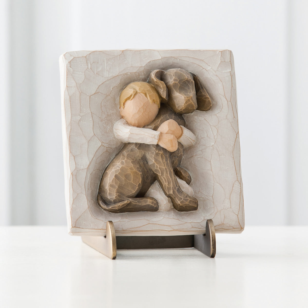 Cream square plaque stand with boy hugging brown puppy carved in