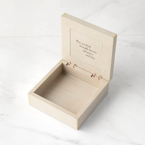 Cream box open to show inside reads "May you find strength, beauty and peace each day"