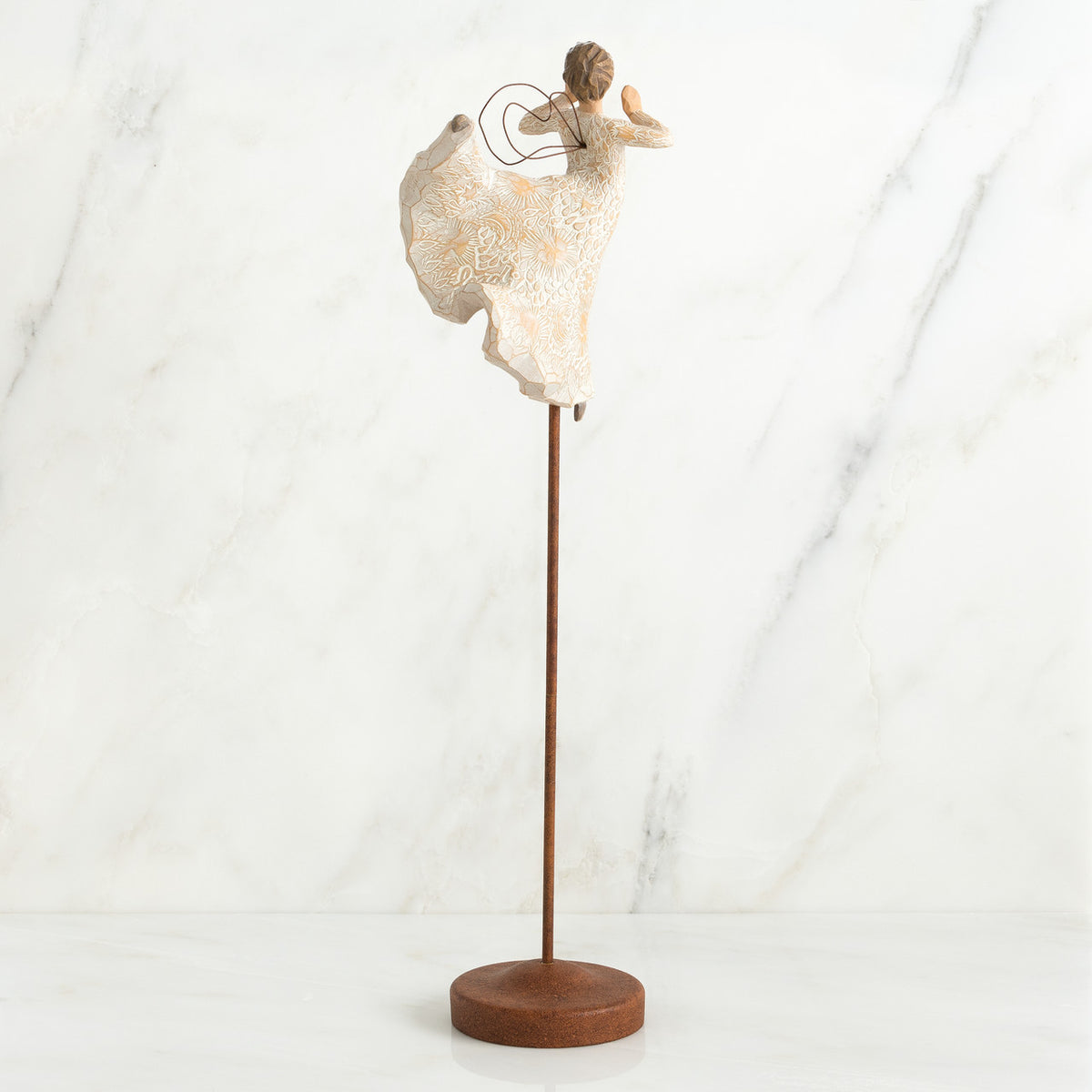 Back view of brunette angel figurine in white dress with arms up, standing on large wooden stand