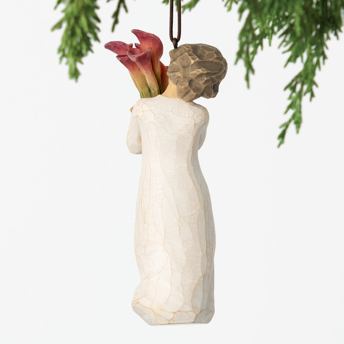 Back view, female figure in cream dress, holding tall bouquet of fuchsia calla lilies. Hook and loop affixed to head