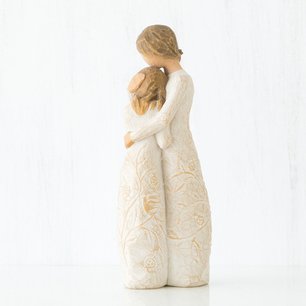 Side view of two brunette girls in white dresses hugging another