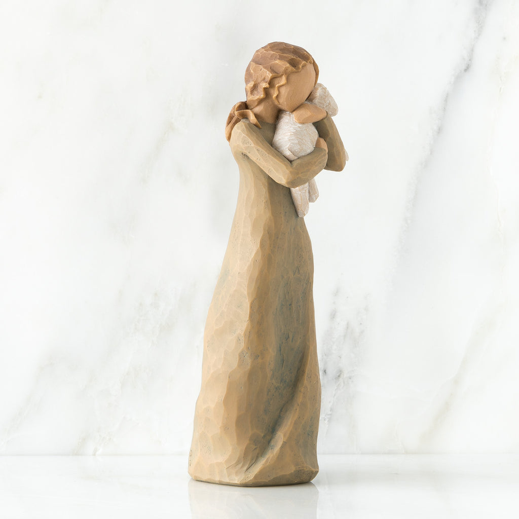 Woman figurine in brown dress holding baby in white