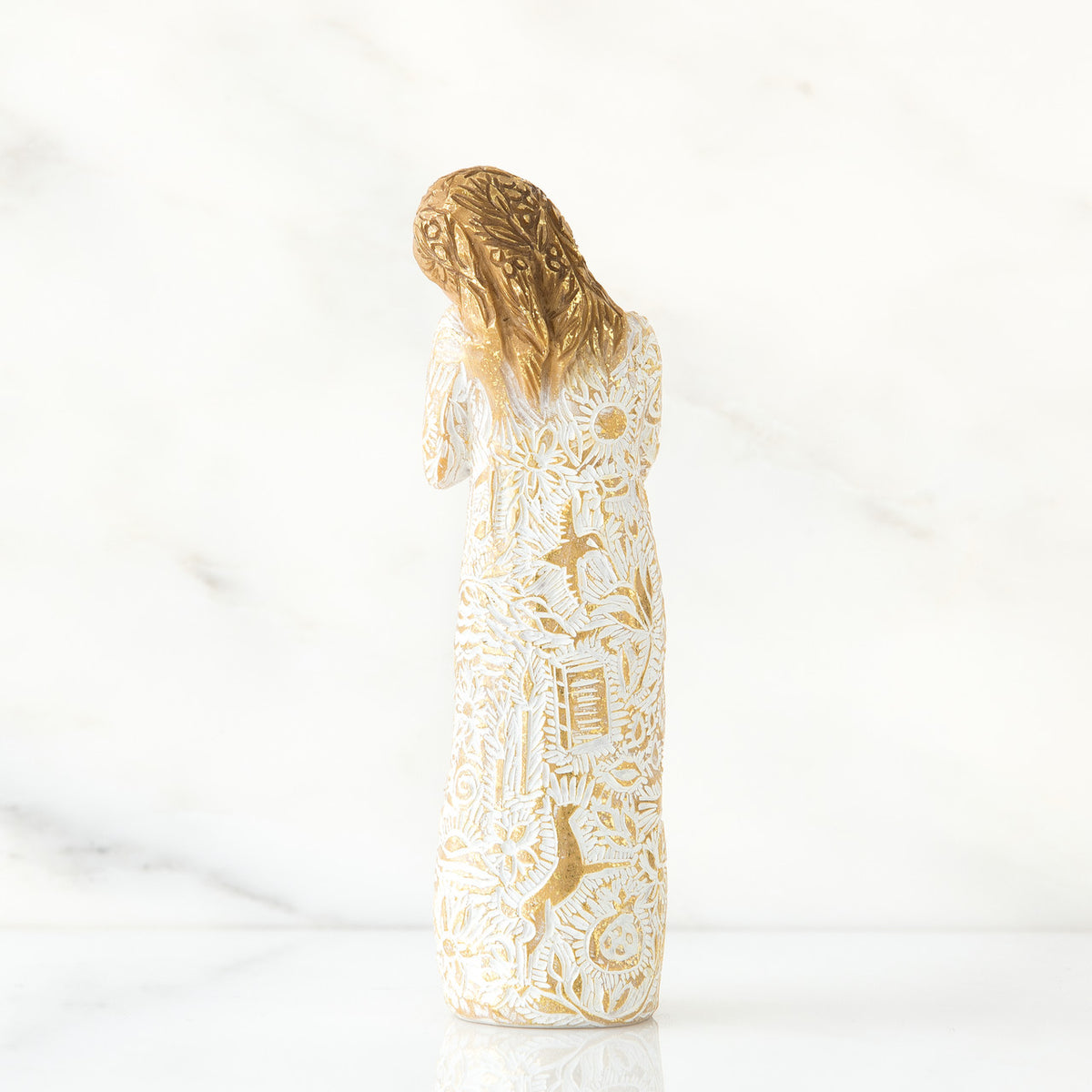 Gold haired woman figurine in white/gold dress facing away from the front