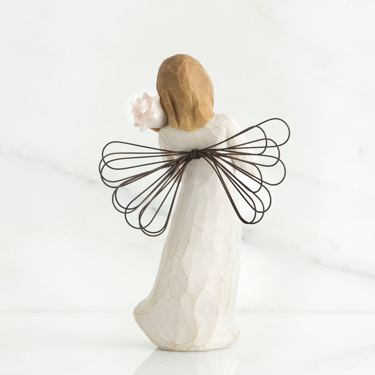 Back view of blonde angel figurine with brown wire wings and white dress