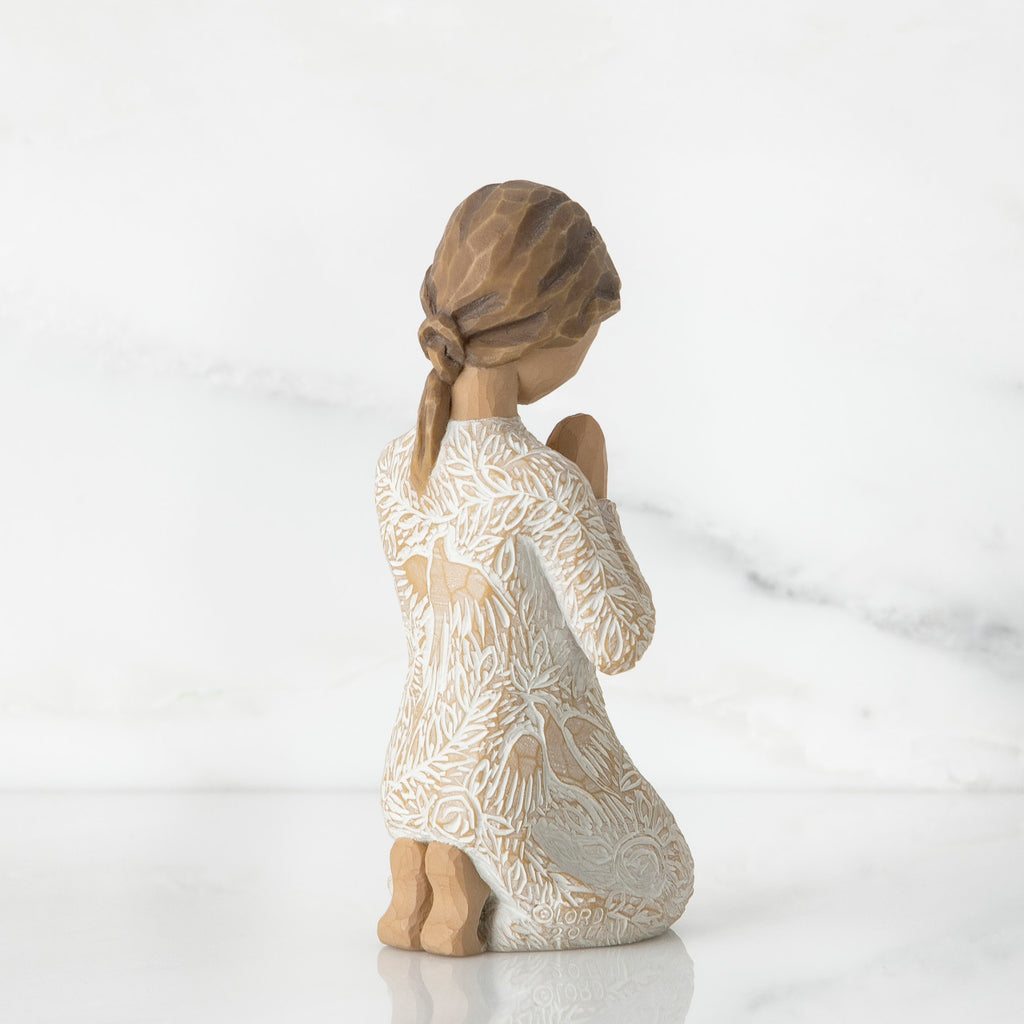 Back view of little brunette girl kneeling in white dress