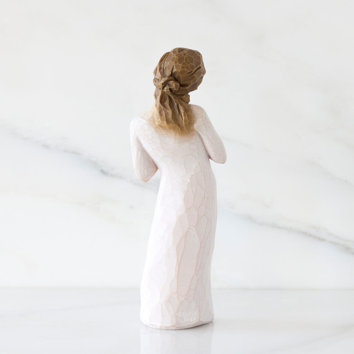Back view: Standing figure in cream dress with hands to heart in empathetic gesture