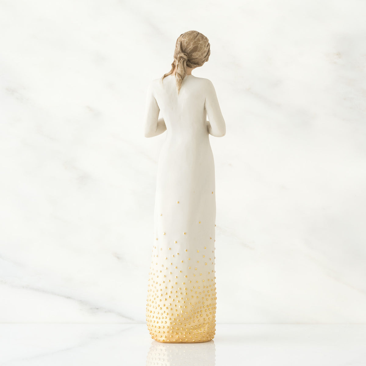 Back view of brunette woman wearing white dress with gold bottom