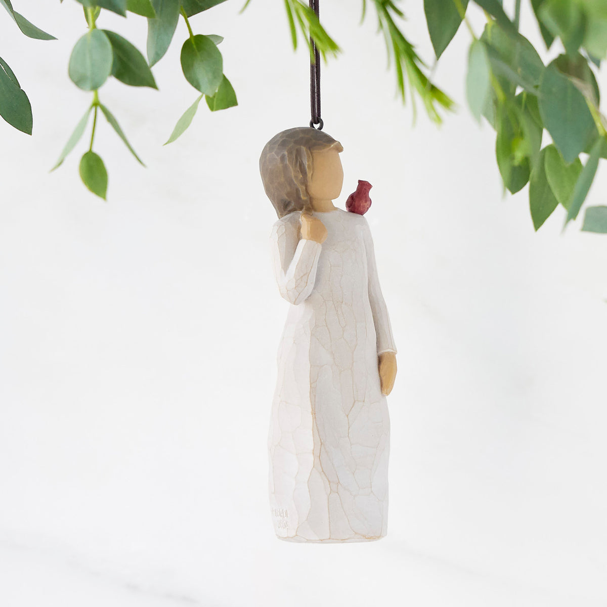 Right side of figure in cream dress with cardinal red bird perched on shoulder, hook & loop in head