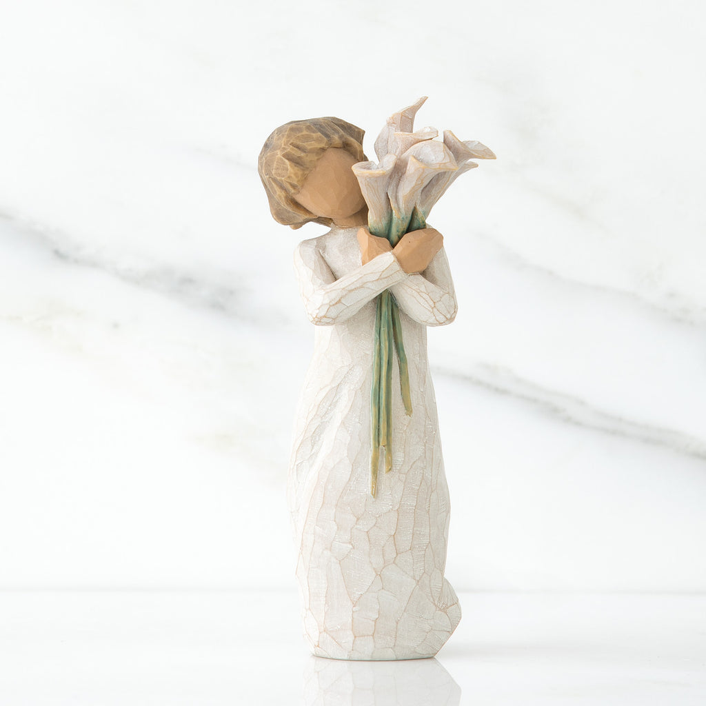 Front view of lIttle girl with short brown hair holding a cluter of white calla lilies