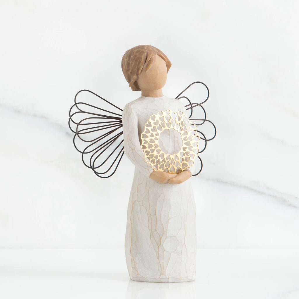 Front view of angel with short, light brown hair holding a metallic wreath of hearts with both hands