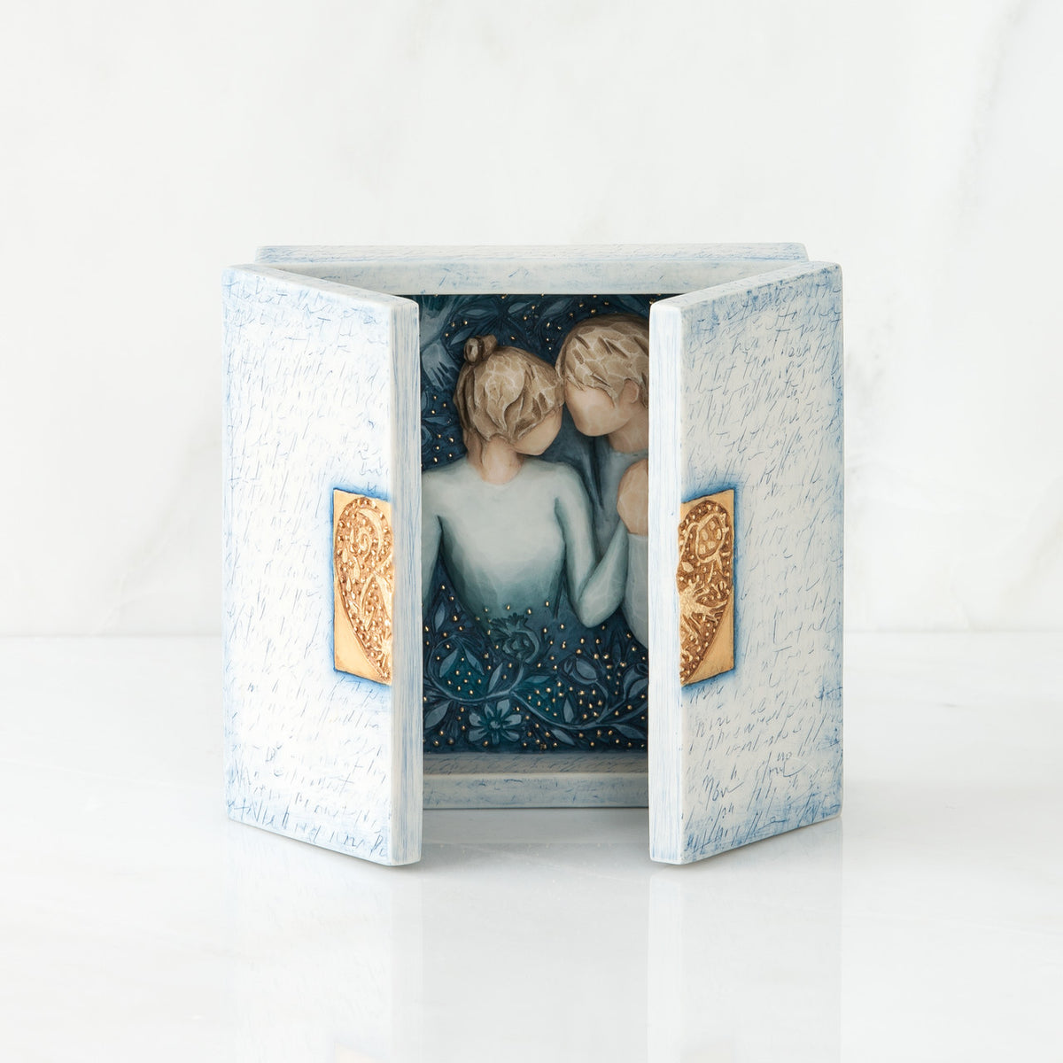 White/blue open box with two man and woman figurines inside holding hands