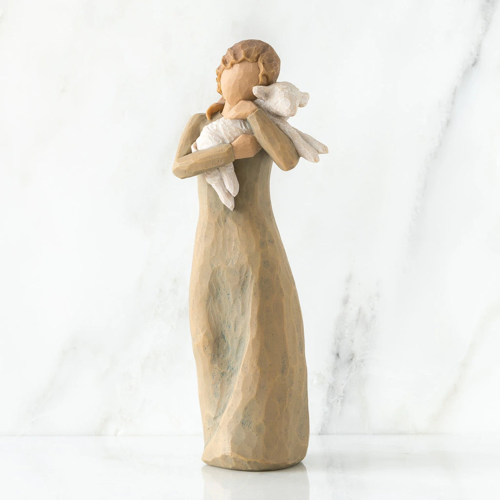 Faceless woman figurine standing wearing light tan dress holding white lamb in her arms