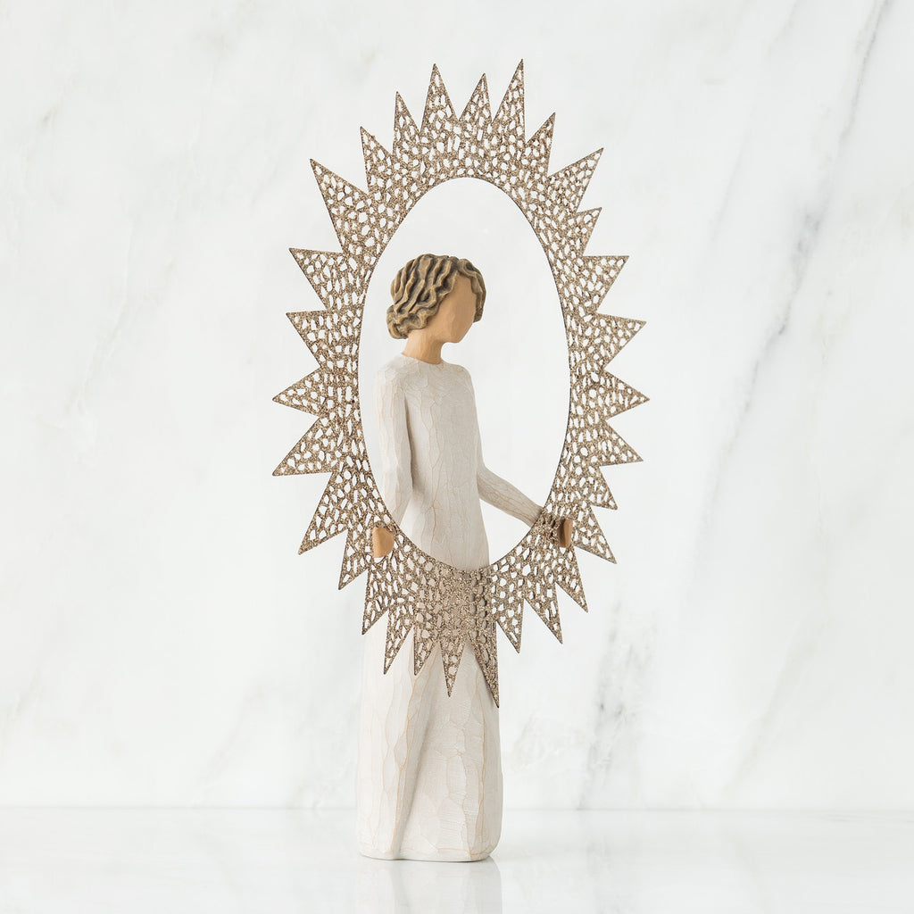 Brunette girl figurine in white dress holding up rose gold sun figurine