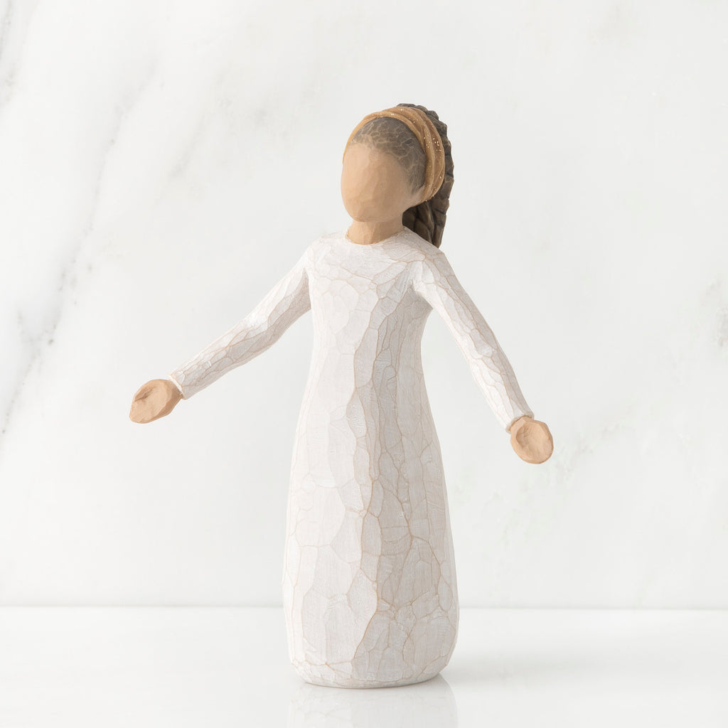 Young faceless girl figurine standing wearing all white dress with her arms out