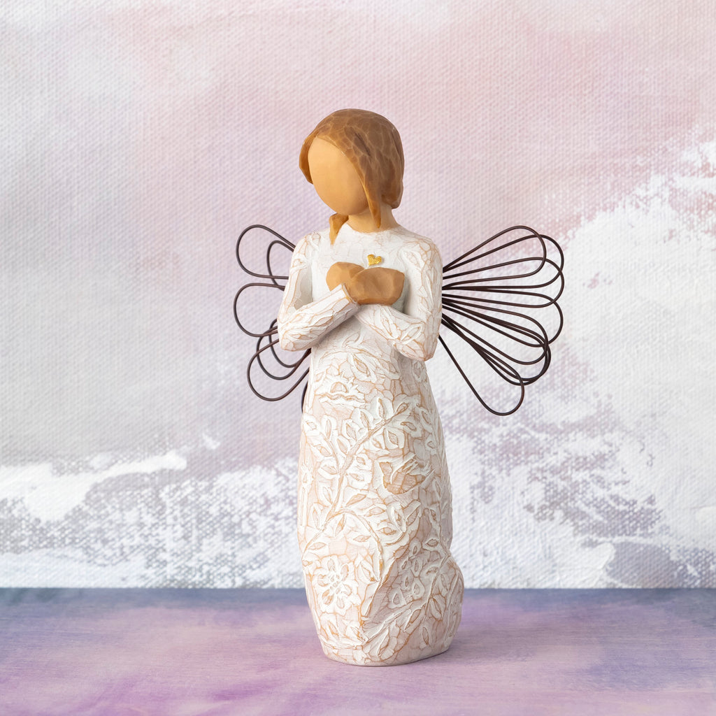 Willow Tree Remembrance, 5”h hand-painted standing resin angel figure in cream dress carved with symbols of nature, wire wings, crossed hands under small gold-leaf heart, in front of pale purple painting