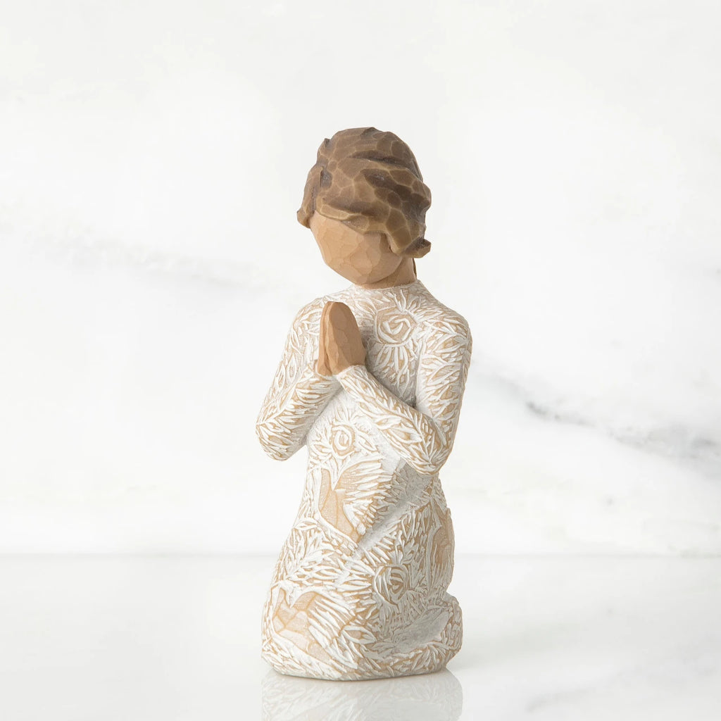 Small faceless girl figurine wearing white/tan bird design dress, kneeling and praying