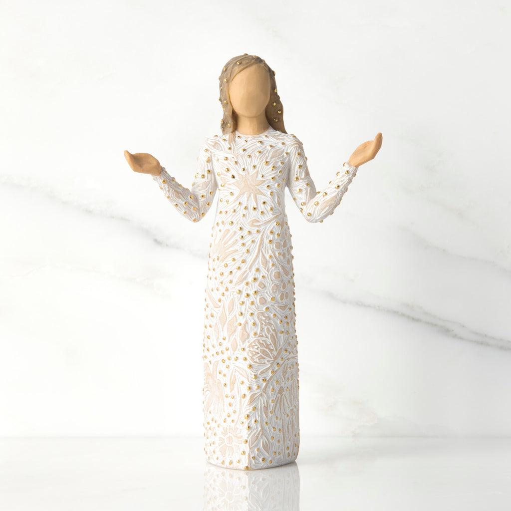 Front view of brunette girl figurine in white dress with gold dots holding her hands to the side