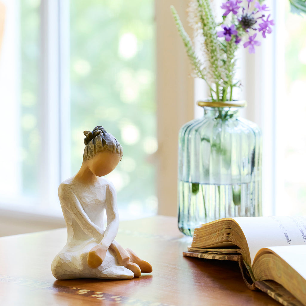 Willow Tree Serenity, 3.5”h hand-painted seated figure in cream dress, arms crossed in balletic pose, on table by window