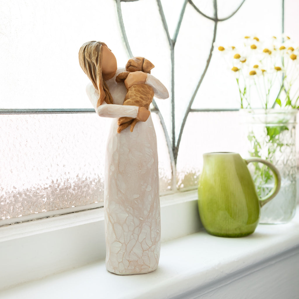 Willow Tree Adorable You (golden dog), 7.5”h hand-painted standing resin figure in cream dress, holding puppy, on bright windowsill